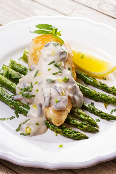 Kızarmış tavuk göğsü üzerinde kuşkonmaz tarhun ve mantar sos ile