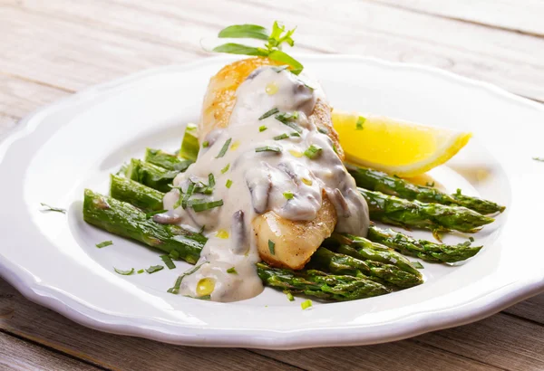 stock image Fried chicken breast on asparagus with tarragon and mushroom sauce