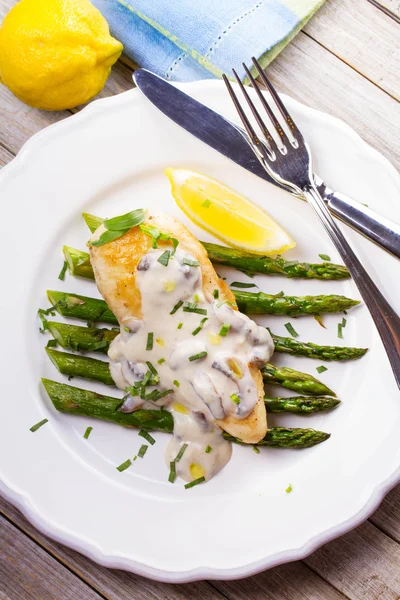 Gebakken kippenborst op asperges met Dragon en champignonsaus — Stockfoto