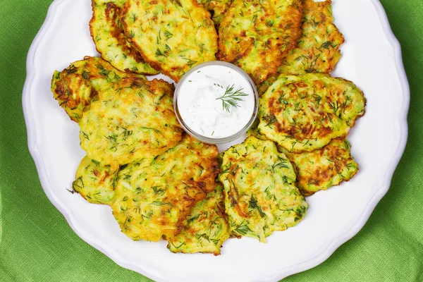 Zucchini Pancakes With  Sour Cream in White Plate