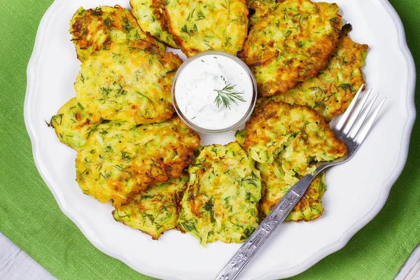 Zucchini Pancakes With  Sour Cream in White Plate