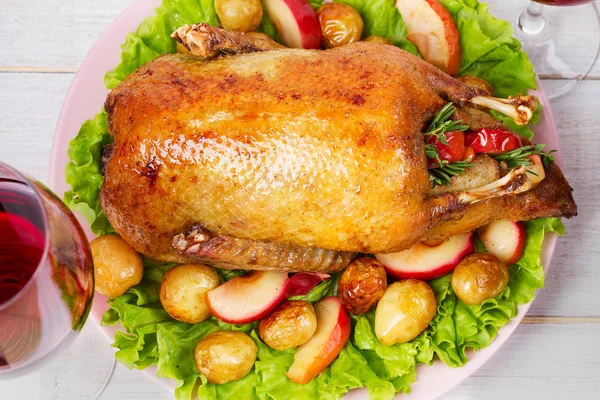 Жареная утка с картошкой, яблоками, салатом, тимьяном и розмарином — стоковое фото
