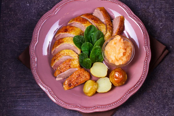 Pechuga de pato, salsa de manzana, espinacas y papas, servidas en plato rosado — Foto de Stock