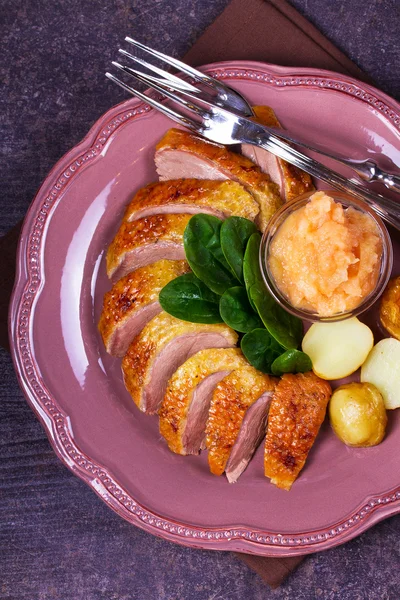 Entenbrust, Apfelmus, Spinat und Kartoffeln, serviert auf rosa Teller — Stockfoto