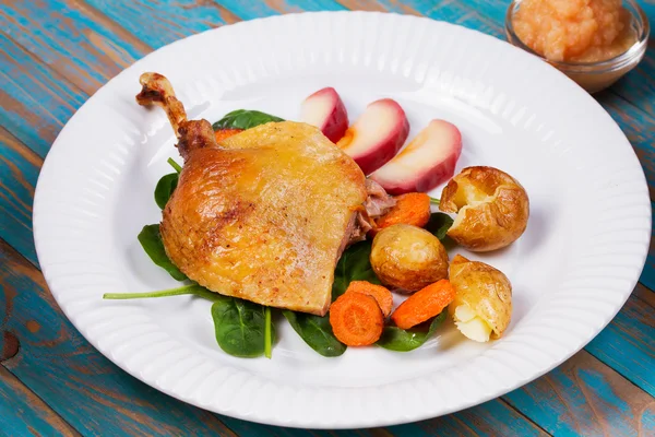 Ispanak, patates, elma sosu ve havuç mavi ahşap arka plan üzerinde ördek