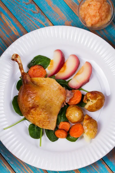 Ispanak, patates, elma sosu ve havuç mavi ahşap arka plan üzerinde ördek