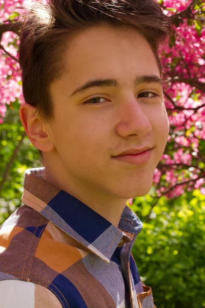 Зовнішній портрет хлопчика-підлітка. Красивий підліток в парку сакура — стокове фото