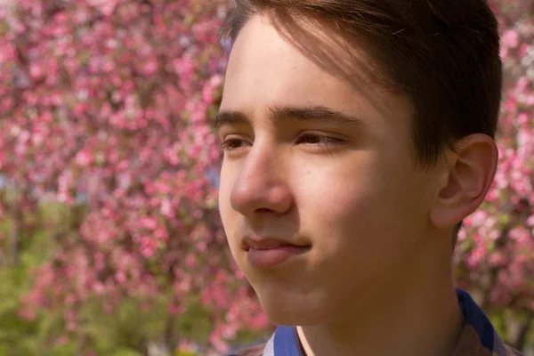 Portret poza teen chłopiec. Przystojny nastolatek w parku sakura — Zdjęcie stockowe