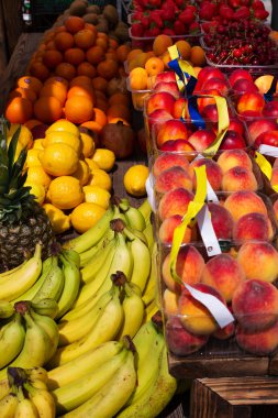 Elma, limon, portakal, nar, ananas, şeftali ve çilek. Bir sokak pazarında çeşitli meyve