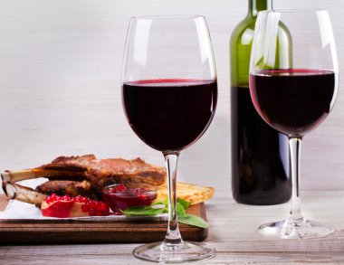 Kırmızı şarap gözlük. Nar sosu ve yeşillik ile kuzu raf. Yukarıda görmek, en iyi stüdyo vurdu