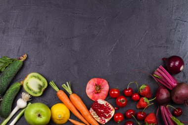 Havuç, kırmızı pancar, salatalık, limon, nar, kivi, elma, domates, kiraz, çilek, kırmızı soğan, fesleğen ve nane. Yukarıdan görünüm, en iyi stüdyo shot sebze ve meyve