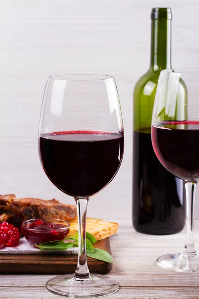 Red wine glasses. Rack of lamb with pomegranate sauce and greens. View from above, top studio shot