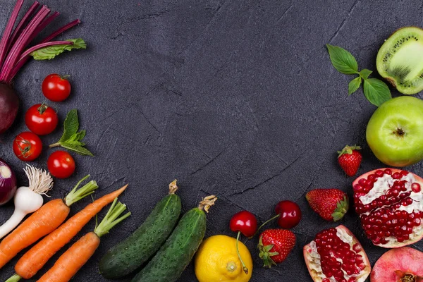 Wortel, rode biet, komkommer, citroen, granaatappel, kiwi, appels, tomaten, kersen, aardbei, rode ui, basilicum en munt. Weergave van bovenaf, top studio shot van groenten en fruit — Stockfoto