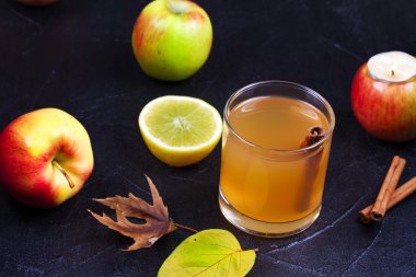 Elma, limon ve siyah arka plan üzerine tarçın elma suyu cam