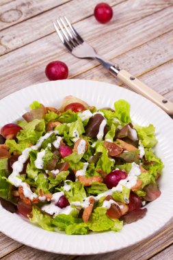 Tavuk ve kırmızı üzüm beyaz tabak salata. 