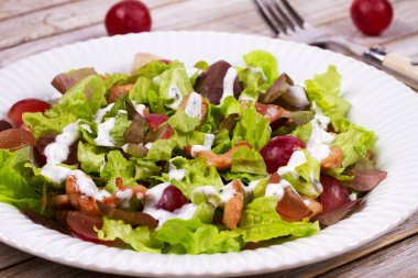 Tavuk ve kırmızı üzüm beyaz tabak salata. 
