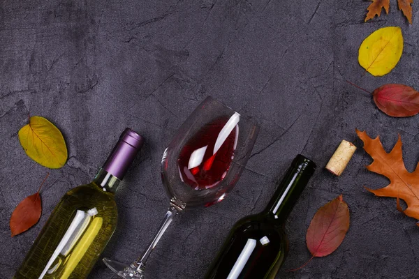 Kırmızı ve beyaz şarap kadehi ve şişe. Üzüm ve fındık siyah arka plan üzerine — Stok fotoğraf