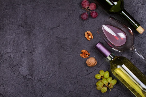 Rode en witte wijn glas en fles. Druif en noten op zwarte achtergrond — Stockfoto