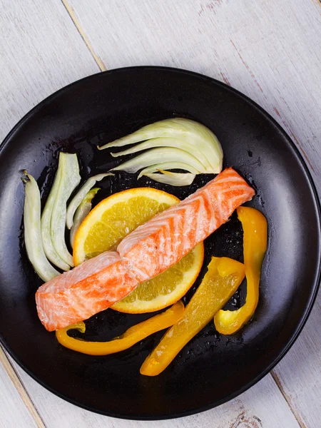Steamed Salmon with Fennel, Pepper and Oranges on Black Plate — Stock Photo, Image