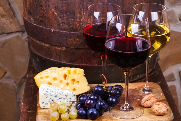 Κόκκινο, Ροζέ και λευκών ποτήρια και μπουκάλια κρασί με σταφύλια στο κελάρι κρασιού — Φωτογραφία Αρχείου