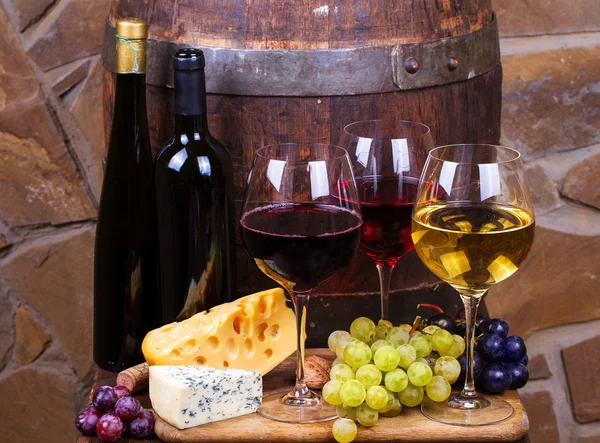 빨강, 장미 및 백색 안경 및 와인 저장 고에서 포도와 와인의 병 — 스톡 사진