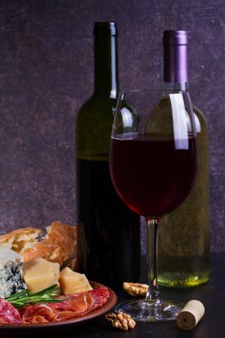 Mavi peynir, parmesan, salam, prosciutto, zeytin, biberiye ve ekmek ile kırmızı şarap