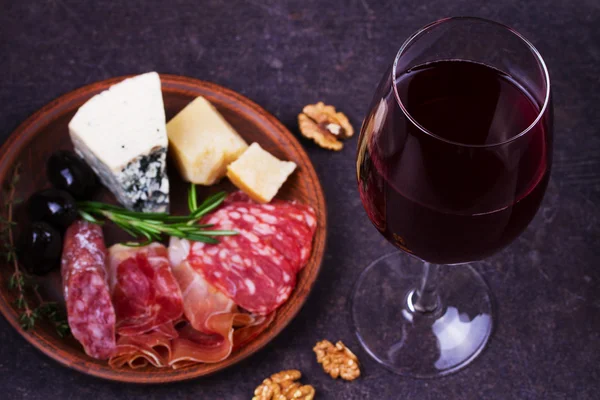 Red wine with blue cheese, parmesan, salami, prosciutto, olives, rosemary and bread — Stock Photo, Image