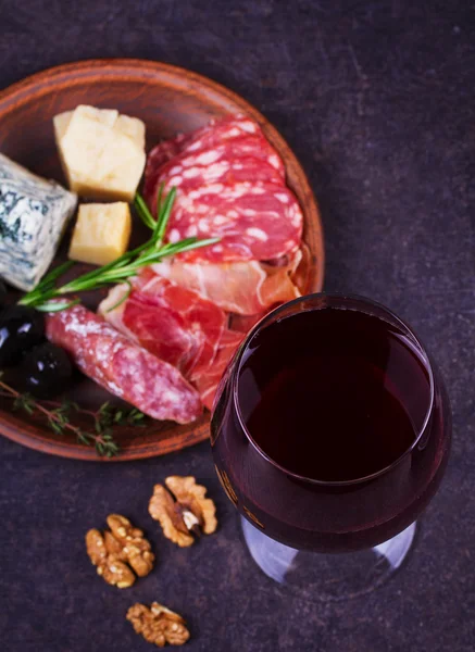 Red wine with blue cheese, parmesan, salami, prosciutto, olives, rosemary and bread — Stock Photo, Image