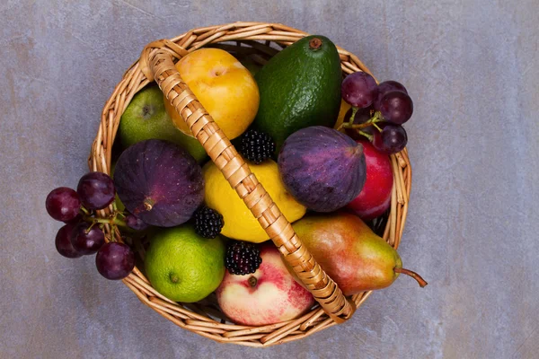 Figs, lemon, lime, plums, grape, blackberries, avocado, apples, pears and peaches in basket — Stock Photo, Image