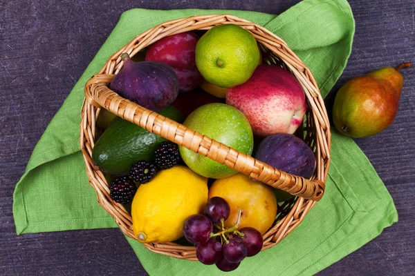 Figs, lemon, lime, plums, grape, blackberries, avocado, apples, pears and peaches in basket — Stock Photo, Image