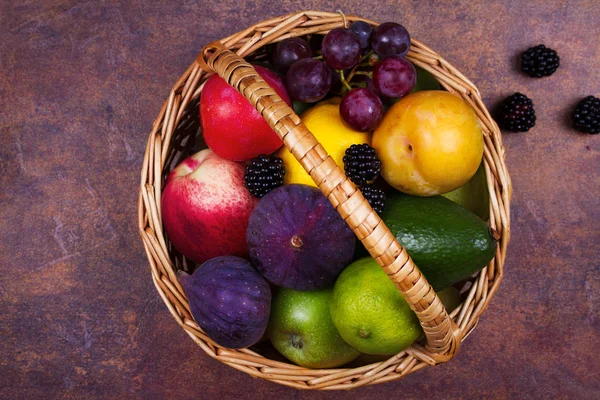 Figs, lemon, lime, plums, grape, blackberries, avocado, apples, pears and peaches in basket — Stock Photo, Image