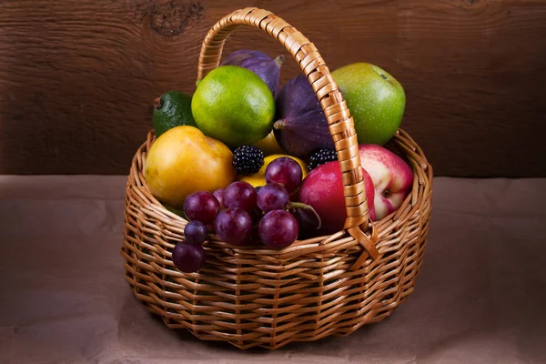 Figi, cytryny, limonki, śliwki, winogrona, jeżyny, awokado, jabłka, gruszki i brzoskwinie w koszyku — Zdjęcie stockowe