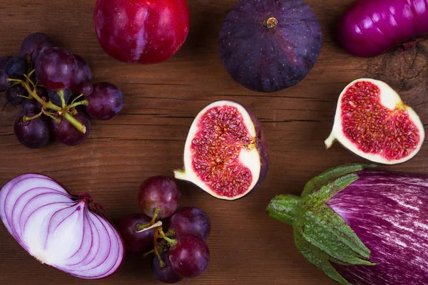 Maturare fichi viola, prugne, uva, melanzane e cipolla. Natura morta di frutta e verdura su sfondo di legno — Foto Stock