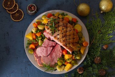 Kızarmış jambon ve sebze. Noel süsleri. Yeni yıl yemeği masası. Yukarıdan bak, en iyi stüdyo çekimi.