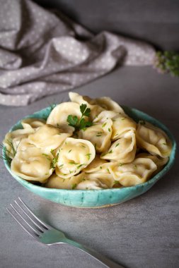 İçi et dolu börekler. Gri arka planda kaseyi dolduran hamur köfteleri. dikey resim