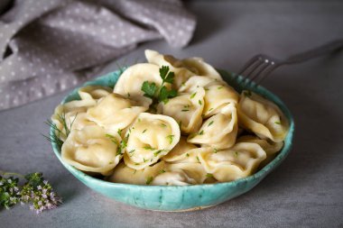 İçi et dolu börekler. Gri arka planda kaseyi dolduran hamur köfteleri. yatay resim