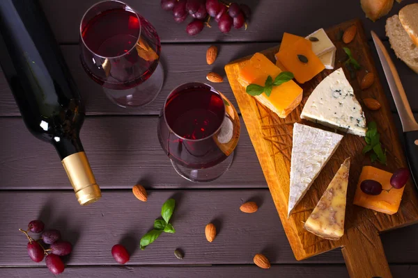 Ποτήρια Και Μπουκάλι Κόκκινο Κρασί Τυρί Και Ξηρούς Καρπούς Άποψη — Φωτογραφία Αρχείου