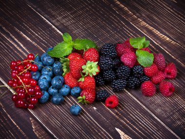 Çilek, yaban mersini, böğürtlen, ahududu ve ahşap arka plan üzerinde Frenk üzümü