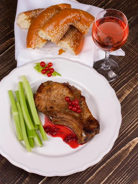 Gebakken pork chop met rode bessen saus en selderij — Stockfoto