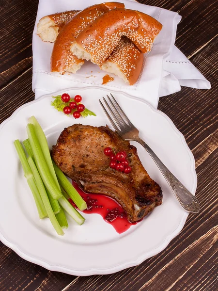 Fried pork chop with red currant sauce and celery — Stock Photo, Image