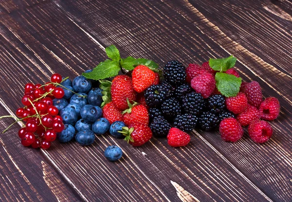 Erdbeeren, Blaubeeren, Brombeeren, Himbeeren und Johannisbeeren auf Holzgrund — Stockfoto