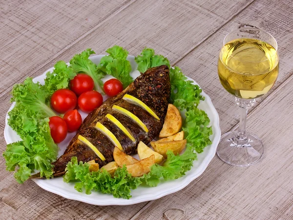 Whole grilled fish carp served with potatoes, tomatoes cherry and salad — Stock Photo, Image