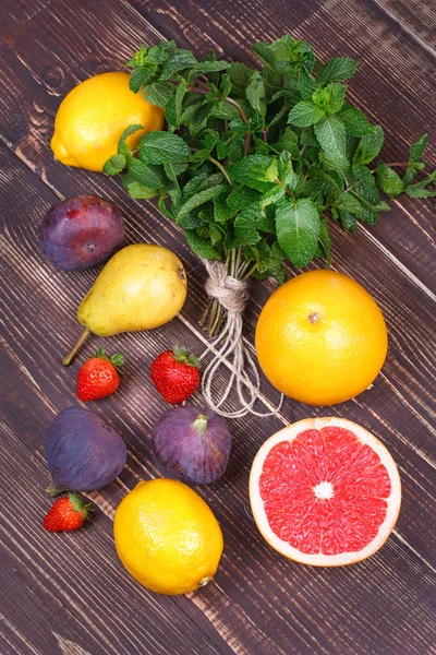 グレープ フルーツ、梨、レモン、イチジク、イチゴ、ザボン、木製の背景にミント — ストック写真