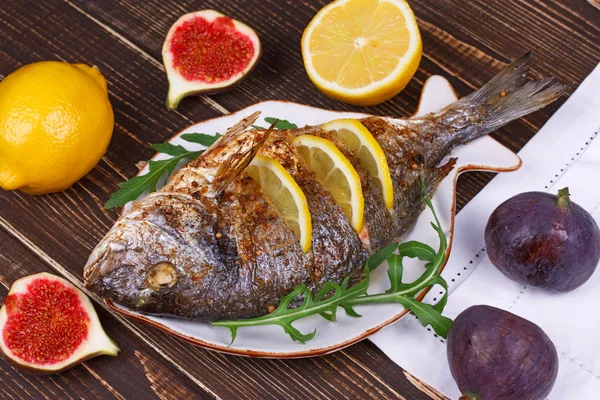 Ολόκληρο ψητό ψάρι dorado σερβιρισμένα με λεμόνι και σύκα — Φωτογραφία Αρχείου