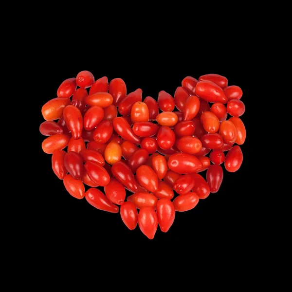 Cornel berries as a heart shape isolated on black background Stock Photo