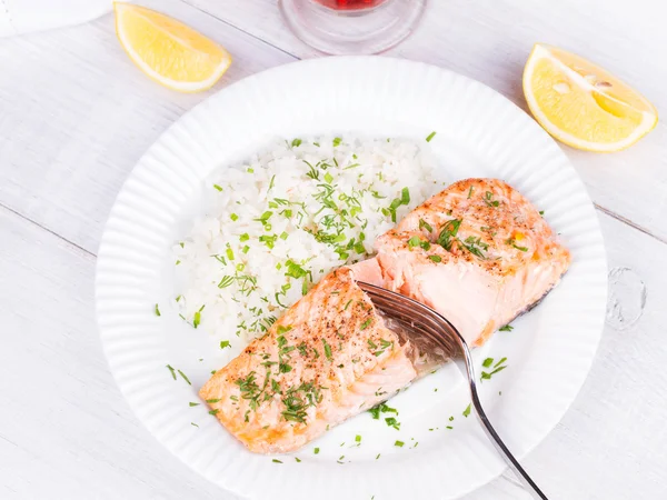 Taze ot ve limon ile haşlanmış somon. Pirinç garnitür olarak