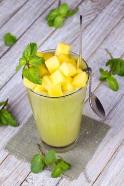 Taze mango meyve suyu bir bardak ve mango dilimleri. Yakın çekim. Stüdyo fotoğrafçılığı.