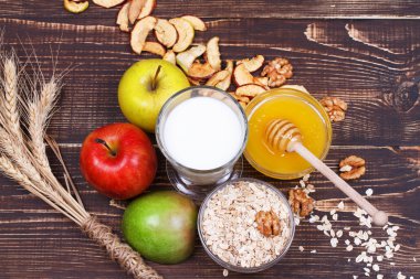 Elma cips, taze elma, bal, süt, yulaf gevreği ve ceviz. Natürmort.
