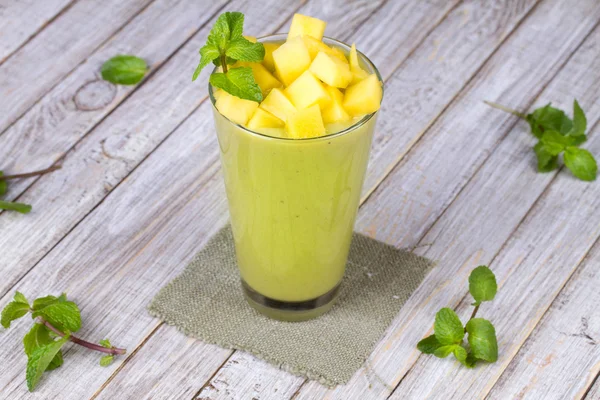 Fresh mango fruit juice in a glass and slices of mango. Close-up. Studio photography. — Stock Photo, Image