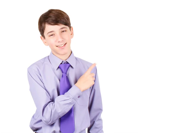 Pointing your product. Portrait of handsome teen boy in shirt and tie pointing copy space and smiling isolated on white background — Stock Photo, Image